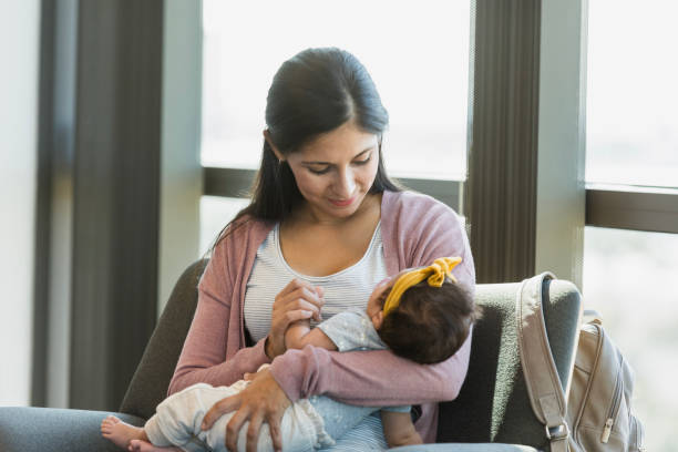istock Tender Mother Holding Sleeping Baby Near Window 2197618095