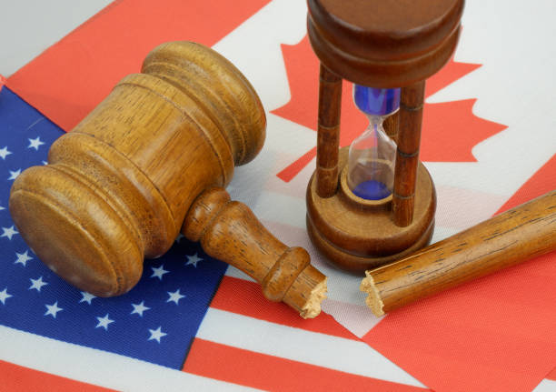 Problems between Canada and USA. Broken judge gavel, hourglass on US and Canadian flags.