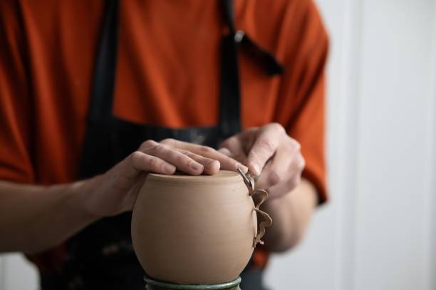 istock A potter works with a tool on a potter's wheel. Close-up of a man's hands. 2197621755