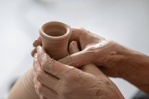 istock Close-up of a potter's hands making a ceramic vase on a potter's wheel. 2197622208