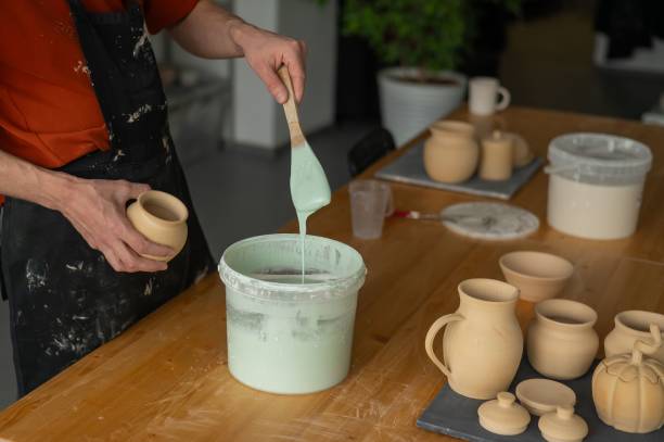 istock Close-up of a potter's hands glazing a pottery piece. 2197622929