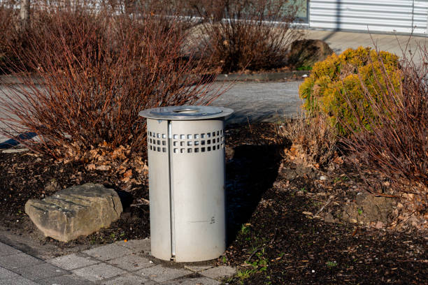istock Urban trash can surrounded by shrubs in a city park area 2197623243