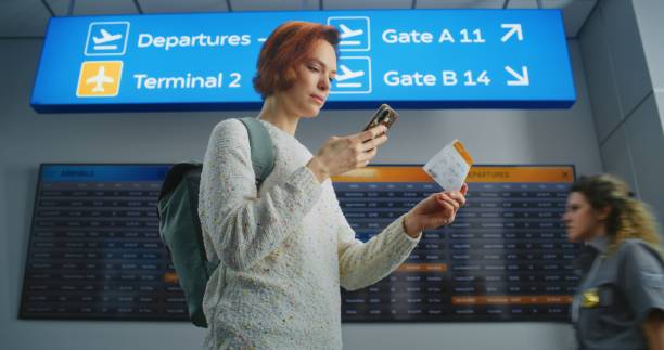 istock Happy Female Passenger Scanning Plane Ticket Using Phone, Going to Boarding Flight 2197623406