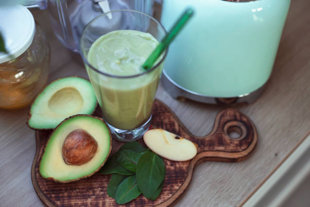 Preparation of healthy green smoothie. Avocado, apple, spinach, honey. Superfoods. Detox. Health and wellbeing.