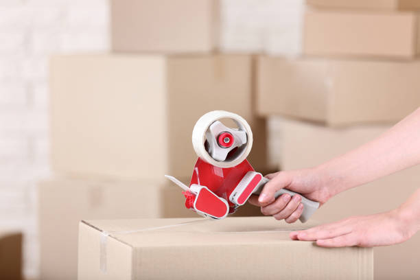 istock Female hands packaging cardboard box with dispenser 2197623859