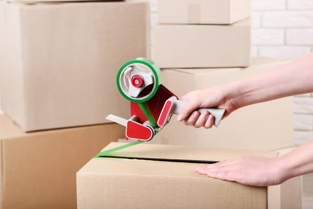istock Female hands packaging cardboard box with dispenser 2197623914