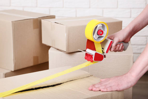 istock Female hands packaging cardboard box with dispenser 2197624002