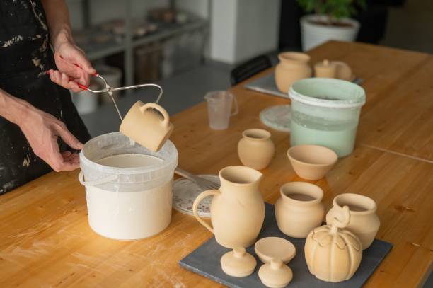 istock Close-up of a potter's hands glazing a ceramic mug. 2197625531