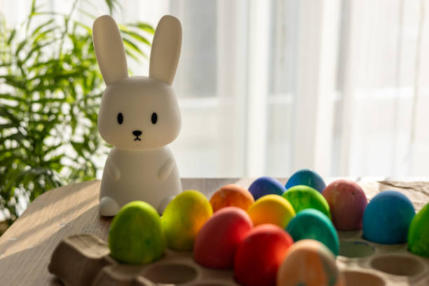 istock Celebrating Easter with colorful eggs and a cute bunny figure in spring sunlight 2197627326