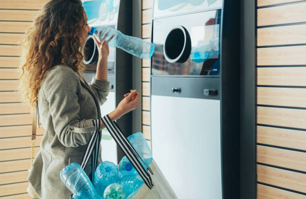 istock Woman recycling plastic bottle via reverse vending machine 2197627758