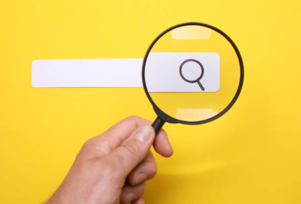 istock Man looks through a magnifying glass at a browser search bar 2197630348