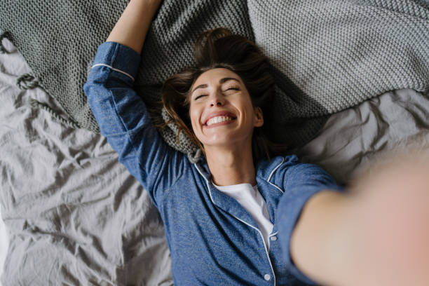 istock Smiling Young Woman Relaxing in Bed 2197631719