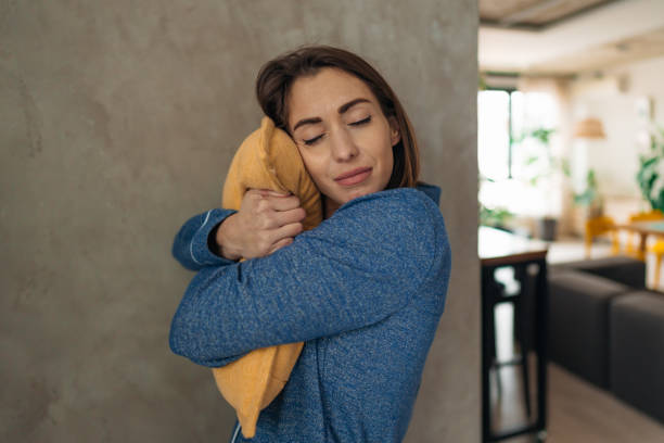 istock Sleepy Young Woman Hugging Pillow in Modern Apartment 2197631784