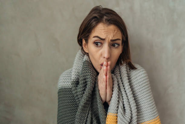 istock Freezing woman warming her hands and shivering from cold 2197631792