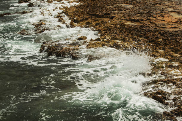 istock Waves Crashing Against Rocky Shoreline 2197631866
