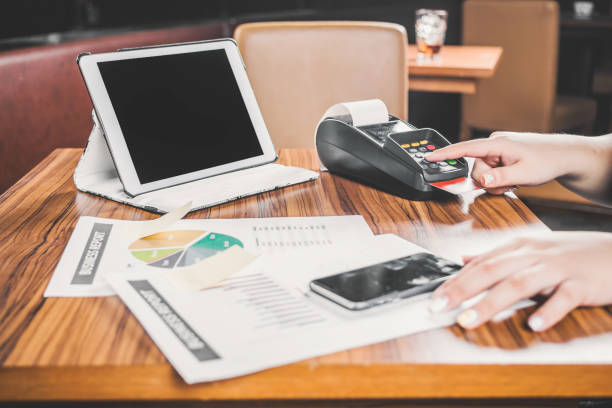 istock woman thumbup checking report with pos device besides 2197632889