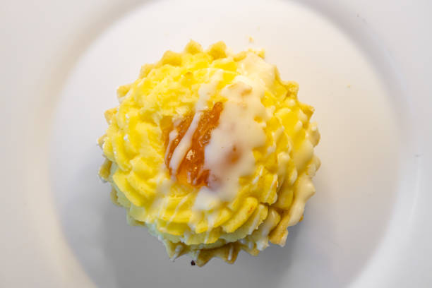 cheese cupcake topped with icing and jam on a cake plate. own baking. coffee dessert.