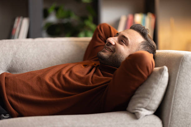 istock Positive, happy man lying on comfortable sofa at home, relaxing after work at home 2197633145