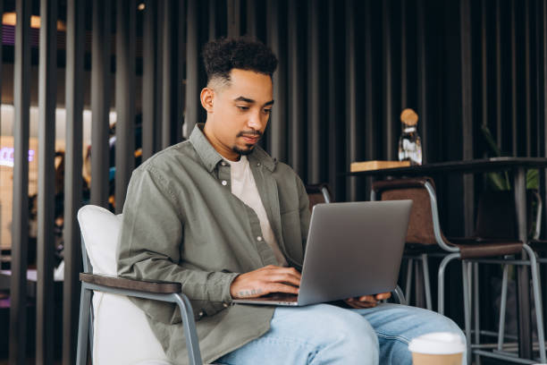 istock Focused freelancer working remotely on laptop in modern cafe 2197634149