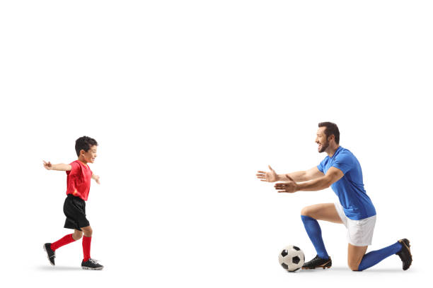 istock Boy running towards a football player 2197634236