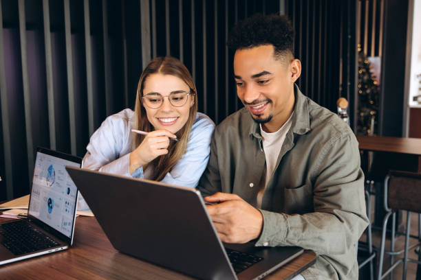 istock Business colleagues analyzing charts on laptop in coworking space 2197636079