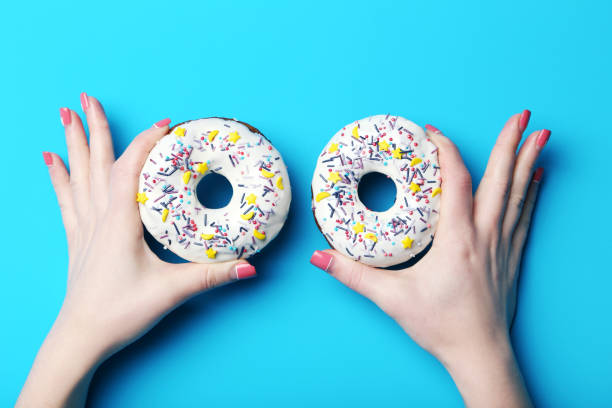 istock Female hands holding sweet donuts with sprinkles 2197636754