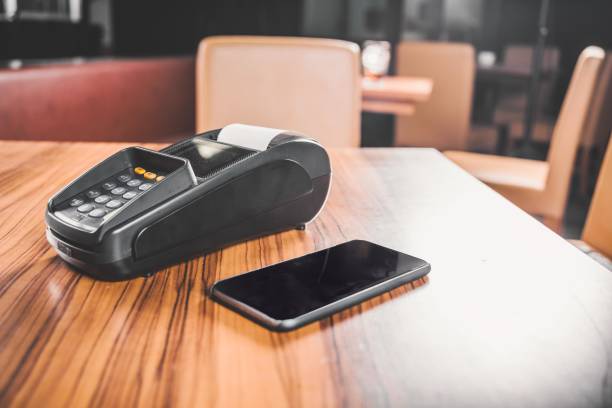 istock Black payment terminal and smartphone on the table 2197636858