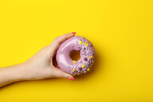 istock Female hand holding sweet donut with sprinkles 2197636902