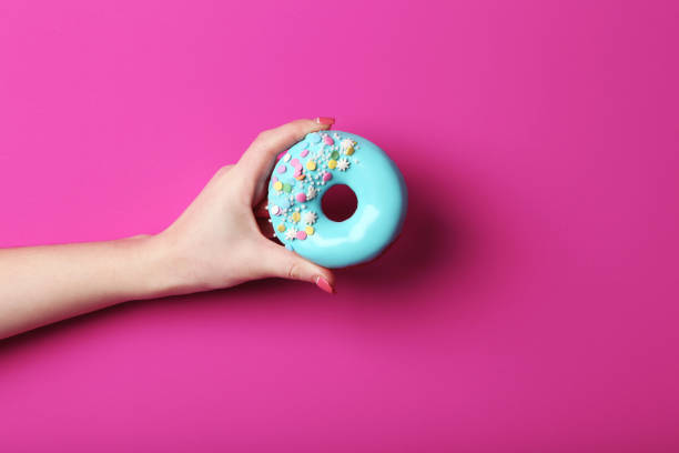istock Female hand holding sweet donut with sprinkles 2197637176