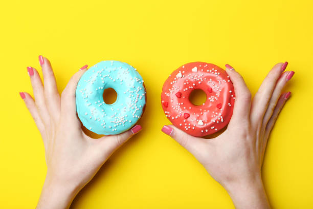 istock Female hands holding sweet donuts with sprinkles 2197637187