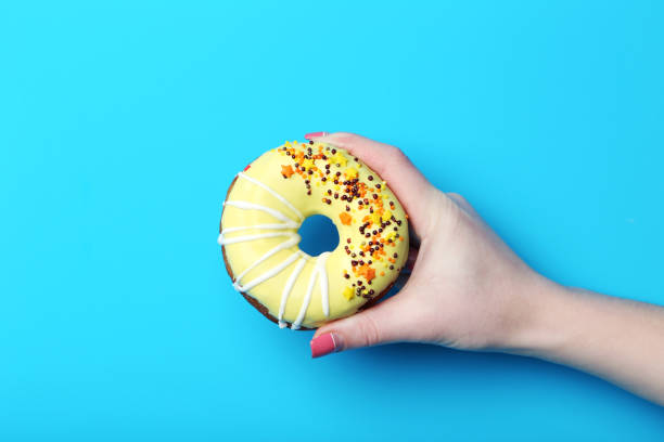 istock Female hand holding sweet donut with sprinkles 2197637230