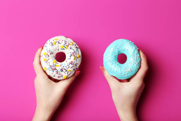 istock Female hands holding sweet donuts with sprinkles 2197637311