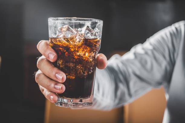 istock A hand holding a glass of cola 2197637625