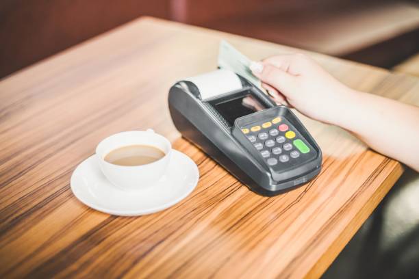 istock A customer using a credit card to pay for a cup of coffee at a cafe. 2197638076