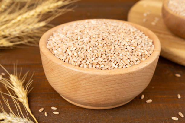 istock Bowl with spelt grain and ears on wooden table 2197638557