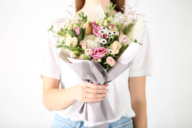 istock Female hand holding beautiful flower bouquet on white background 2197639162