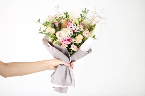 istock Female hand holding beautiful flower bouquet on white background 2197639261