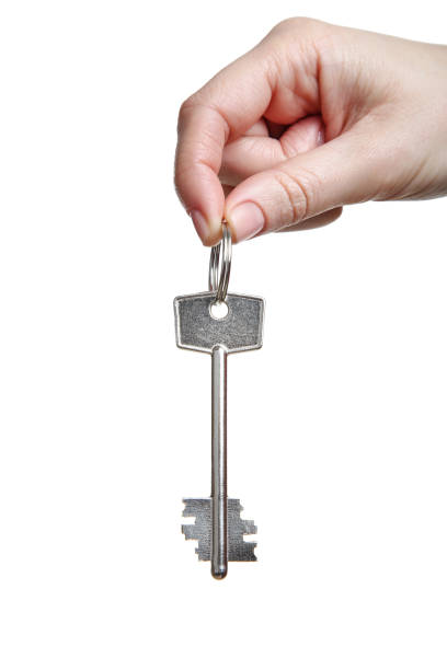 istock Female hand holding house key on white background 2197639686