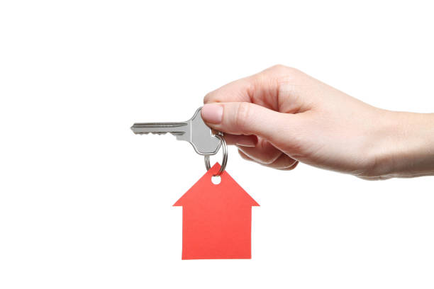 istock Female hand holding silver key with paper house on white background 2197640248