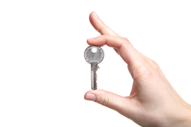 istock Female hand holding house key on white background 2197640351
