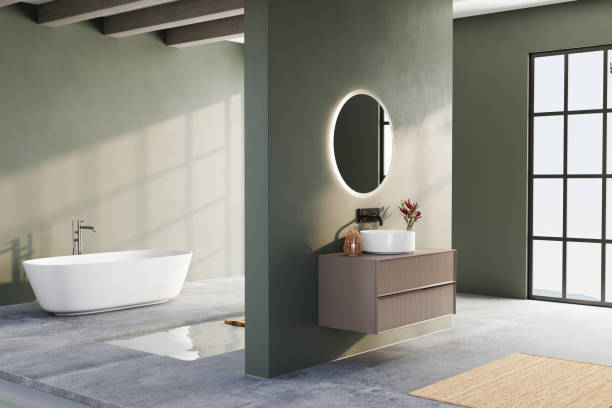 istock Modern bathroom with green walls, round backlit mirror, floating vanity, freestanding bathtub, and minimalist decor in a bright, open space. 3D rendering 2197640398