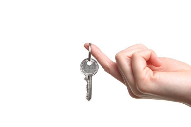 istock Female hand holding house key on white background 2197640537