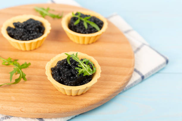 istock Tartlets with black caviar served on on wooden table 2197641756