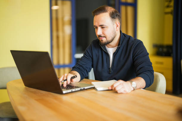 istock European white man working on laptop in office. remote work 2197645316