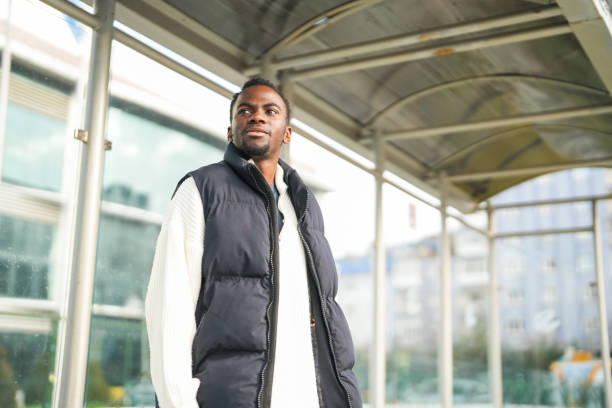 istock african american young man waiting for bus at bus stop 2197646060