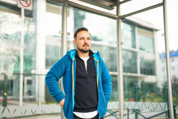istock man waiting for bus at bus stop 2197646288