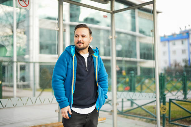 istock man waiting for bus at bus stop 2197646457