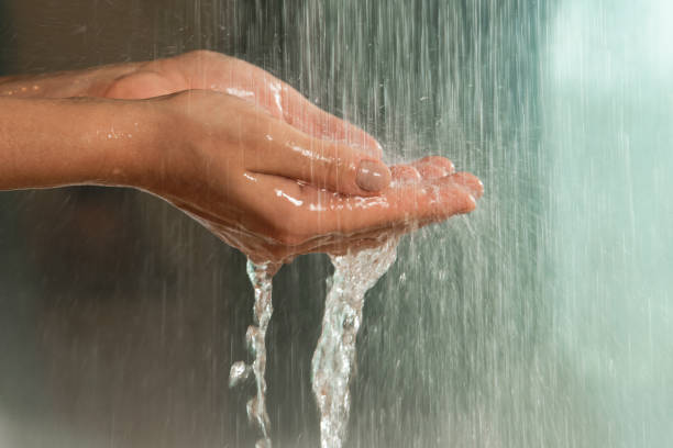 istock Gentle hands under a stream of falling water 2197646749