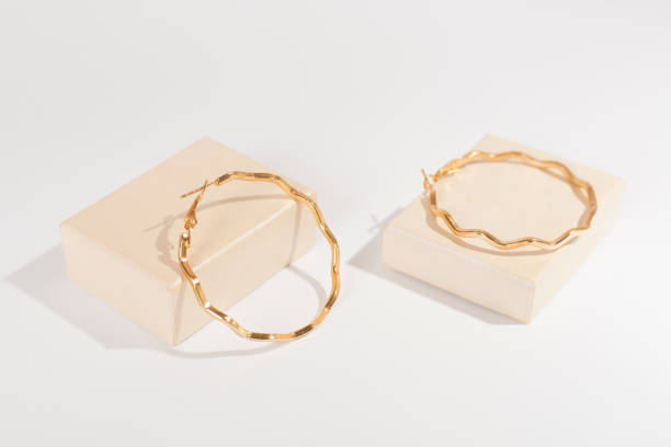 istock Golden earrings with decor on color background 2197646843