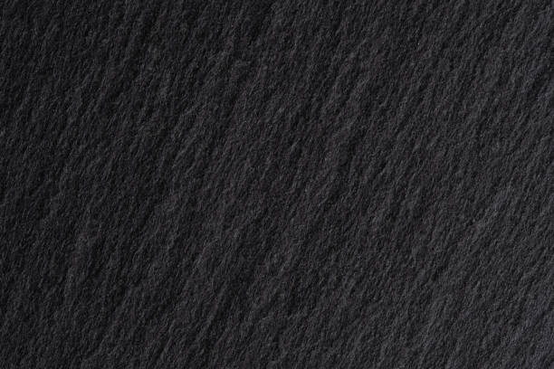 Dark grey black slate background or texture. Close up of black stone